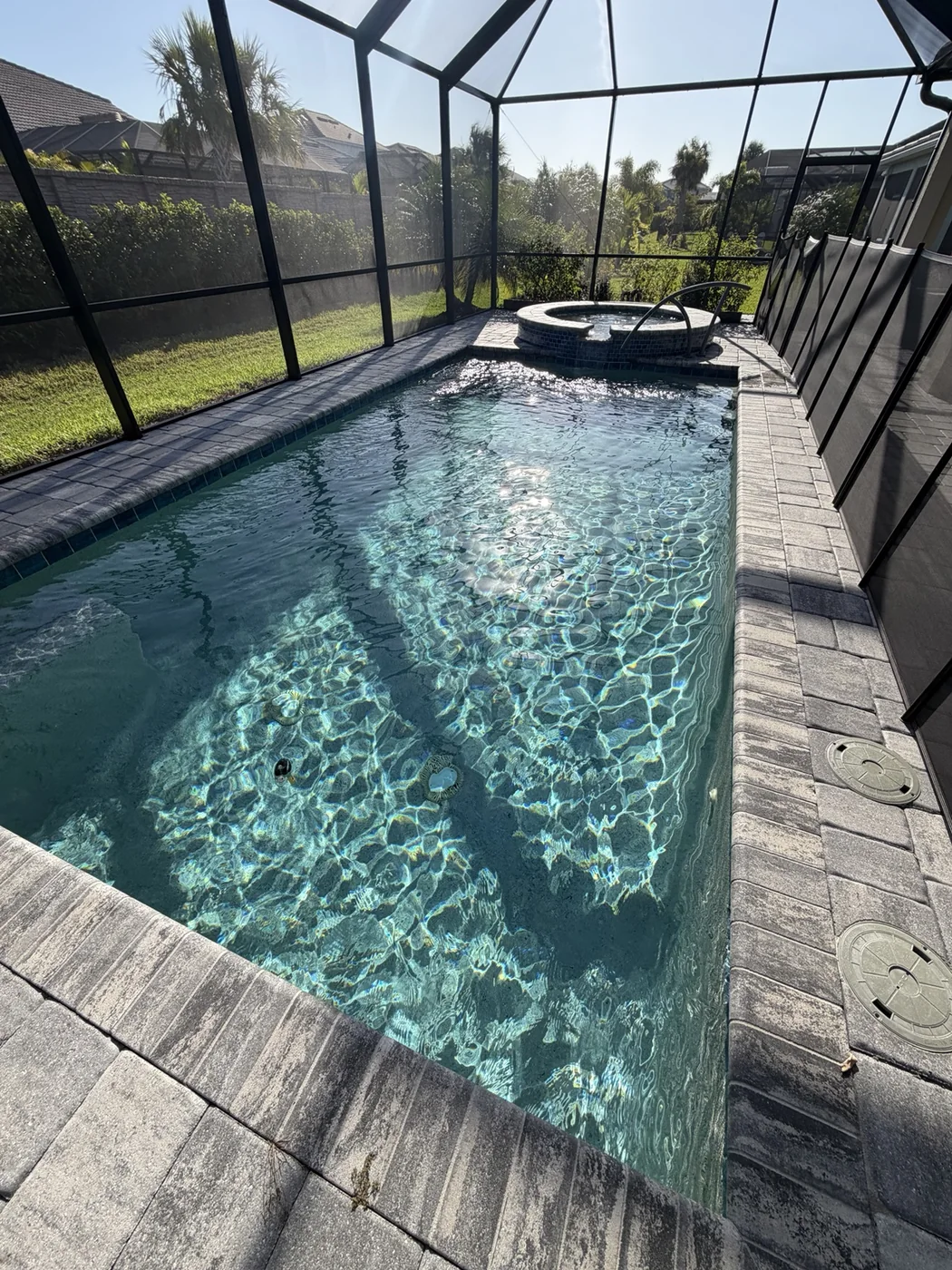A sparkling screened residential pool serviced by K&V Pools